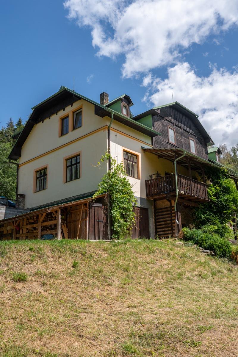 Boční pohled na budovu penzionu HamrákOFF s dřevěnou verandou